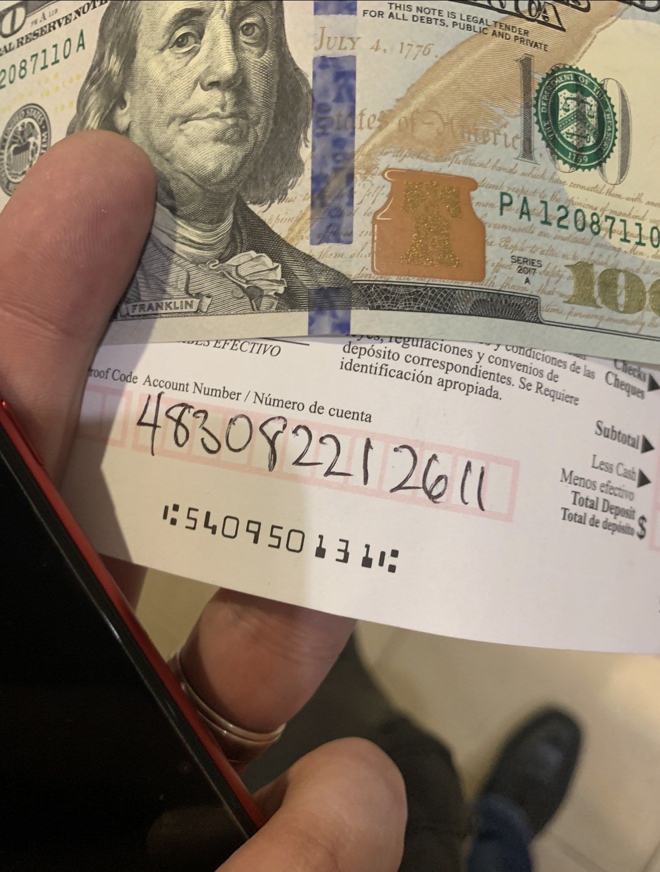 A one-hundred-dollar bill with a Bank of America deposit slip.