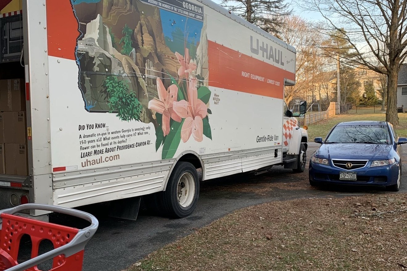 A large U-Haul truck parked in a residential driveway during the fulfillment recovery.